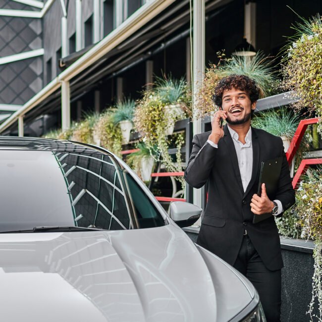 a businessman walks past his car.